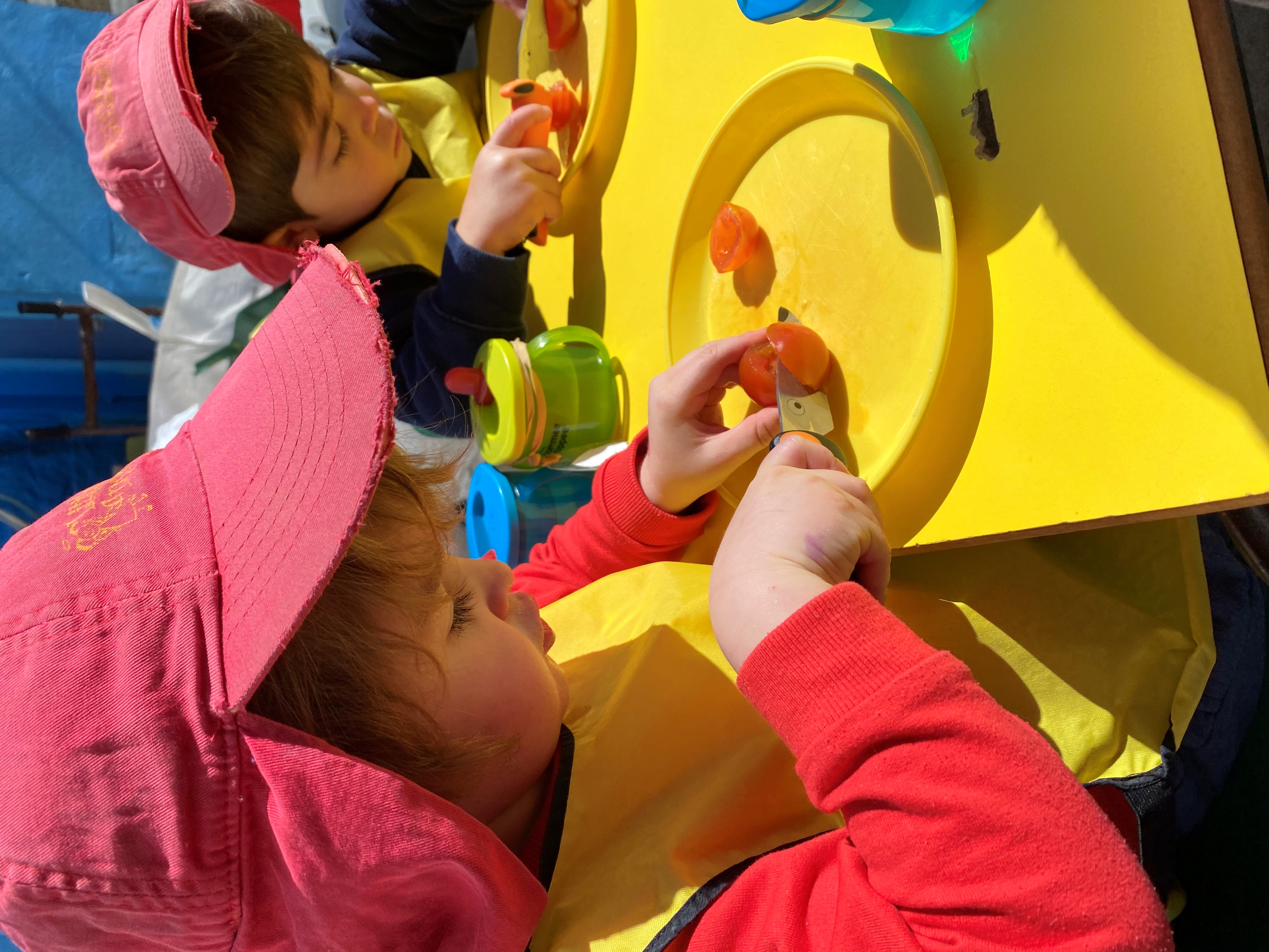 Pre School children chopping vegetables - this forms one of the 8 elements which support children to develop healthy relationship with food