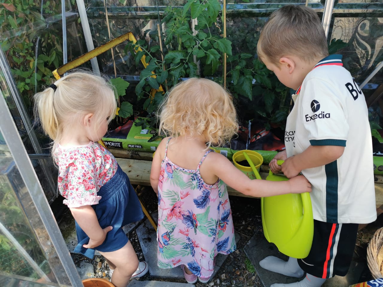 Young children growing vegetables